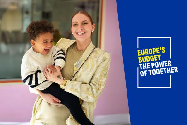 A woman holding a kid with 'Europe's budget, The power of together' written on the side